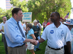 A photograph of Texas politician John Courage at a campaign rally shaking hands with a supporter