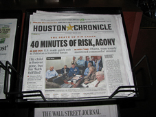 A photograph of a newspaper in a newspaper vendor's box. The paper is the Houston Chronicle.
