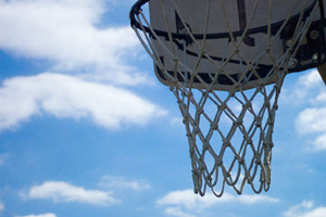 A photograph of a basketball rim, backboard, and net outside. 