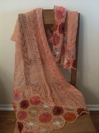 A photograph of a knitted scarf laid over a chair