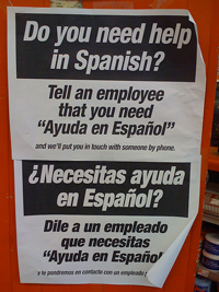 A photograph of a sign that reads “Do you need help in Spanish: Tell an employee that you need 'Ayuda en Espanol.'”