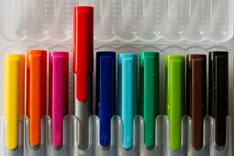 Brightly-colored markers in a row, the red one pulled out and ready for editing. © 2008 by Paul Englefield