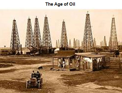 Image of an aged photo of an oil field lined with several oil derricks. A small shack is in the foreground, as well as a model-T ford with two occupants.