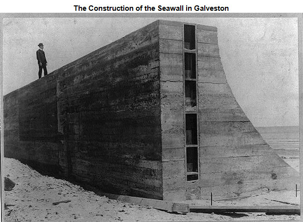 Image of a man standing atop of a portion of the seawall in Galveston