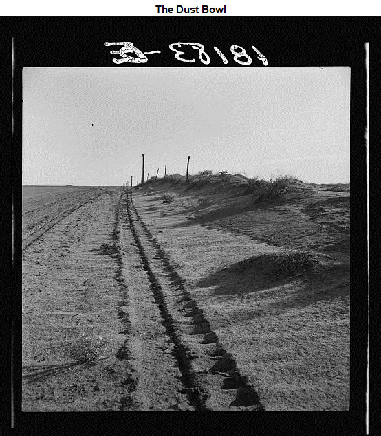 Image of a road covered in dust and sand drifts on either side