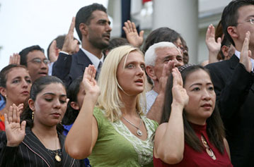 A group of men and women looking out with their right hands up