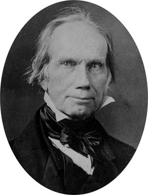 A headshot of Henry Clay, a man with wild gray hair, stern eyes, wearing a black suit and black cravat.