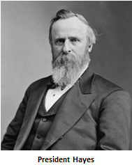 A portrait of a man with a long, sweet beard, parted hair wearing a three-piece suit.
