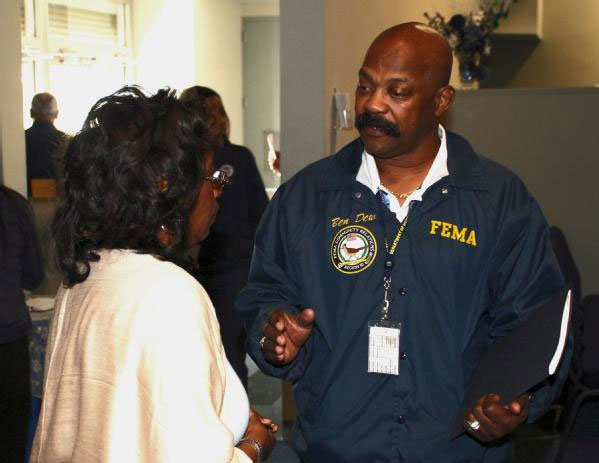 Image of a FEMA worker talking to a victim of Hurricane Katrina.