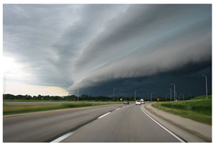 Image of dark clouds approaching the countryside in a swirling pattern.