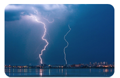 two lightning strikes touching down on a metropolitan city
