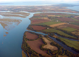 Image of an aerial view of various types of landforms, bordered by bodies of water. 