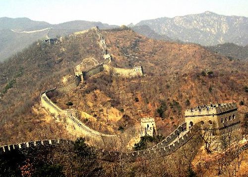 Image of a section of the Great Wall of China. This section expands across a mountain; there are nine visible watchtowers.