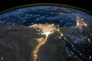 Image of satellite image of lights of Egypt. In this view of Egypt, we see a population almost completely concentrated along the Nile Valley, just a small percentage of the country's land area. The Nile River and its delta look like a brilliant, long-stemmed flower in this astronaut photograph of the southeastern Mediterranean Sea.