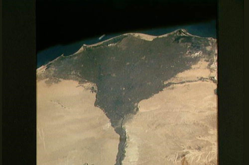 Image of satellite photo of The Nile Delta of Egypt, irrigated by the Nile River and its many distributaries.  The capital city of Cairo lies at the apex of the delta in the middle of the scene. The Suez Canal is just to the right of the delta; the Mediterranean Sea is at the top of the view.