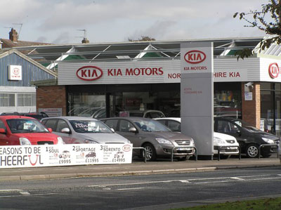 Image of a Kia care dealership parking lot.