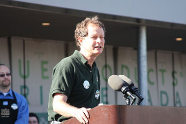 Image of John Mackey speaking at a podium in front of a Whole Foods Market.