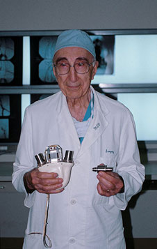 Image of Michael DeBakey holding a model of the artificial heart.