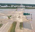 Image of a highway and onramp covered by water. There is a highway sign that is almost at eye-level of the street because of the water.