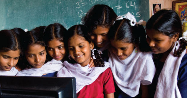 Image of several female students surrounding a computer