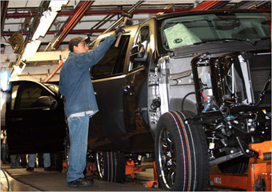 Image of a Mexican worker working on an automobile assembly line