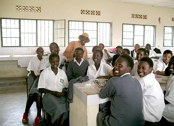 Image of schoolgirls of Rwanda sitting around a long row of tables