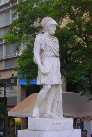 A photograph of a marble statue of Pericles of Athens. He is featured wearing a Greek warrior's helmet and standing atop a block inscribed with Greek letters that spell out his name.