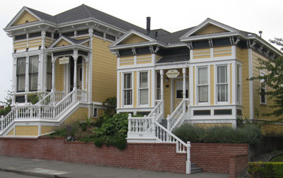 A photograph of two houses on a hill with one house sitting slightly higher than the other.