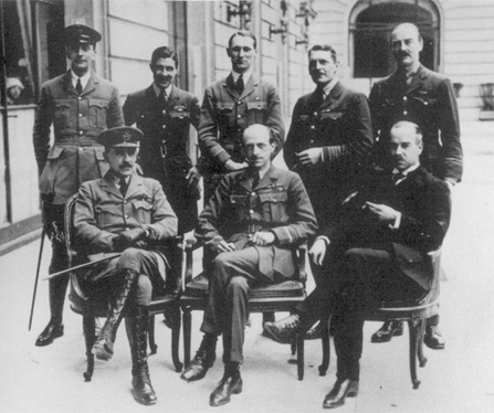 A group of British military officers in attendance at the Paris Peace Conference of 1919. Some men are standing and others are seated.