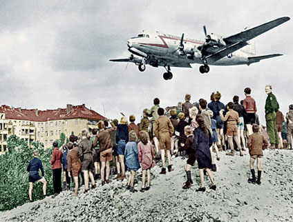 A photograph of United States Air Force aircraft dropping goods and supplies into Berlin, Germany during the Berlin Airlift.