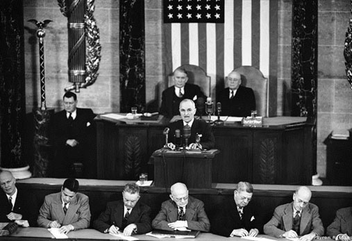 A photograph of President Harry Truman addressing congress on the policy of containment of communism.
