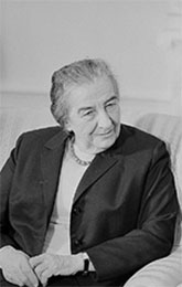Image of Golda Meir seated with hands clasped on her lap.