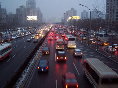 image is many cars driving on a highway