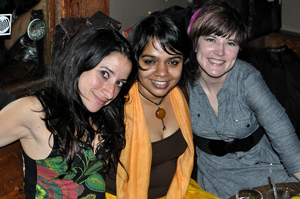 A photo of three young women posing together in a restaurant