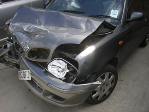 A photograph of a car that has been in an accident. The front of the car is badly damaged.