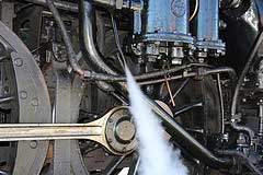 Steam spewing above a locomotive’s wheels