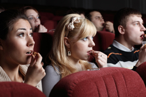 Photo of people in a movie theater. They all look surprised.