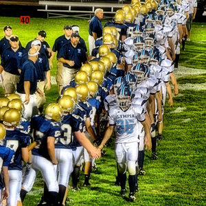 photo of two high school football teams shaking hands after a game