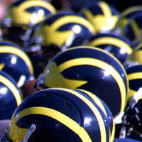 A crowd of blue and gold football helmets