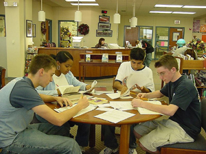 A photograph of students sitting around a table in a library studying