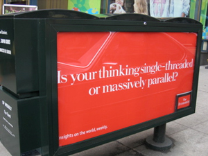 A photograph of an outdoor sign on a city sidewalk that reads: “is your thinking single-threaded or massively parallel?”