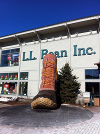 A photograph of the entrance to the L.L. Bean company in Maine. There is a large replica of an L. L. Bean boot next to the building