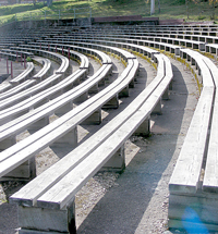 A photograph of rows of parallel benches in an outdoor theater