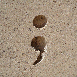 A photograph of a semi-colon carved into stone