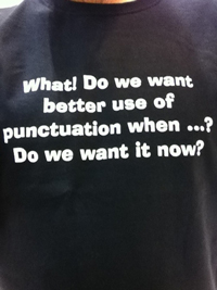 A photograph of a t shirt that reads 'What! Do we want better use of punctuation when…? Do we want it now?'