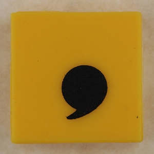A photograph of a comma printed on a tile.