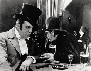 A photograph taken from the 1920 film adaptation of Dr. Jekyll and Mr. Hyde. In the picture Mr. Hyde is speaking to another man. They appear to be plotting something.