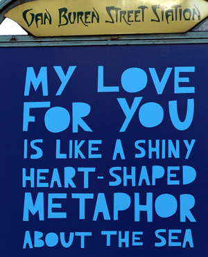 A sign from Van Buren Street Station in Chicago. The sign reads “My love for you is like a shiny heart-shaped metaphor for the sea.”