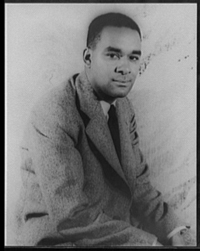 A photograph portrait of author of Richard Wright as a young man. He is seated and wearing a jacket and tie.