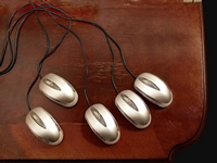 A desk with a collection of identical computer mouses, as if they were all connected to the same computer